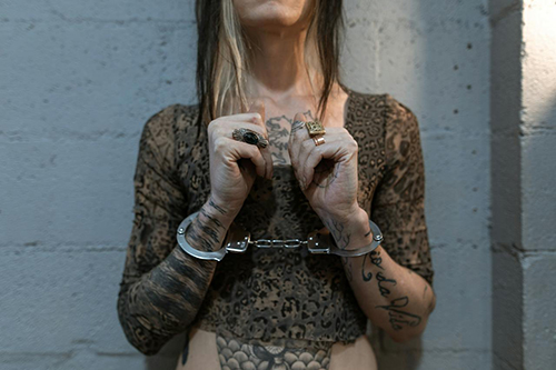 A Woman with Tattoos with Handcuffs