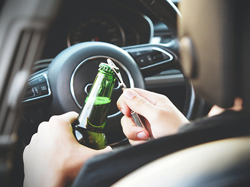 A Person Opening A Bottle In A Car