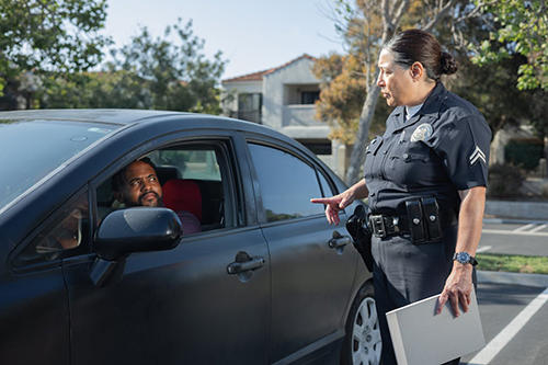 A Police woman Talking to a Man in a Car